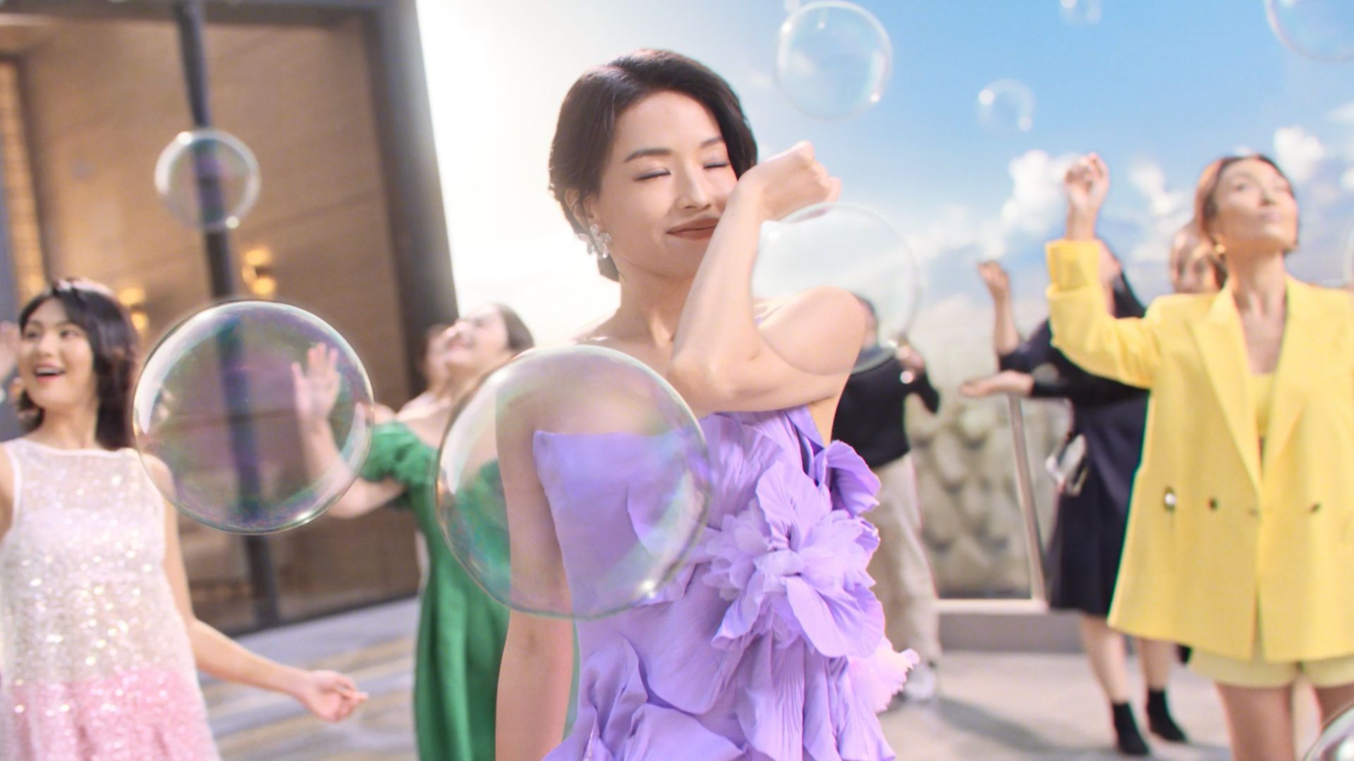 一群穿着色彩鲜艳服装的快乐人们在户外玩泡泡。